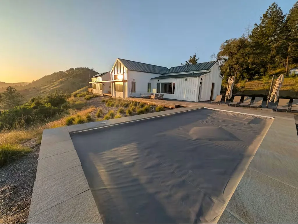 Charcoal gray automatic pool cover closed at sunset