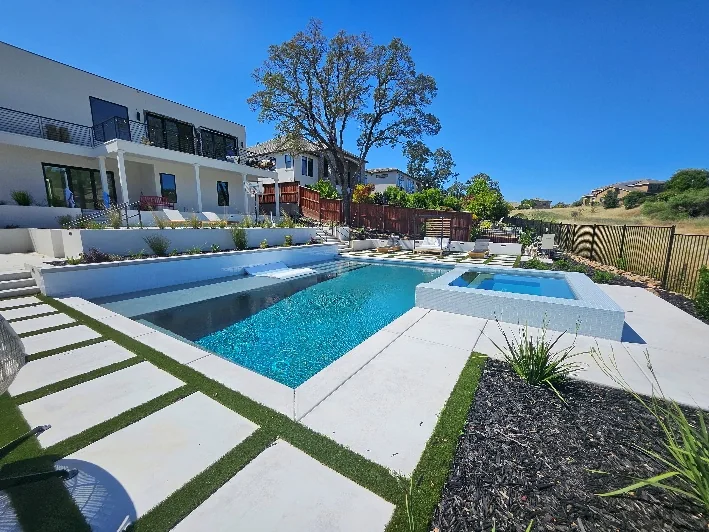 Completed custom pool with terraced hardscape on a sloped lot