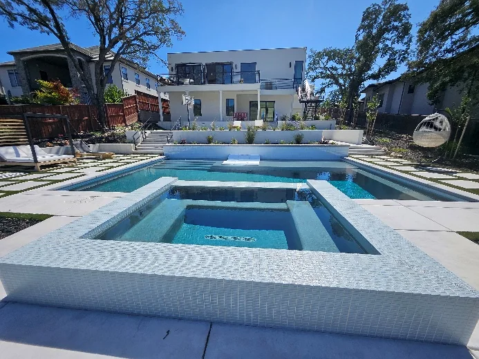 Finished pool and raised spa on a sloped property