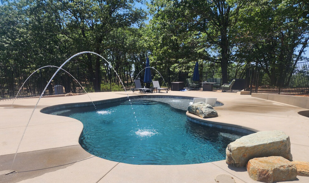 Freeform shaped pool with deck jets and jumping rocks in Nevada City