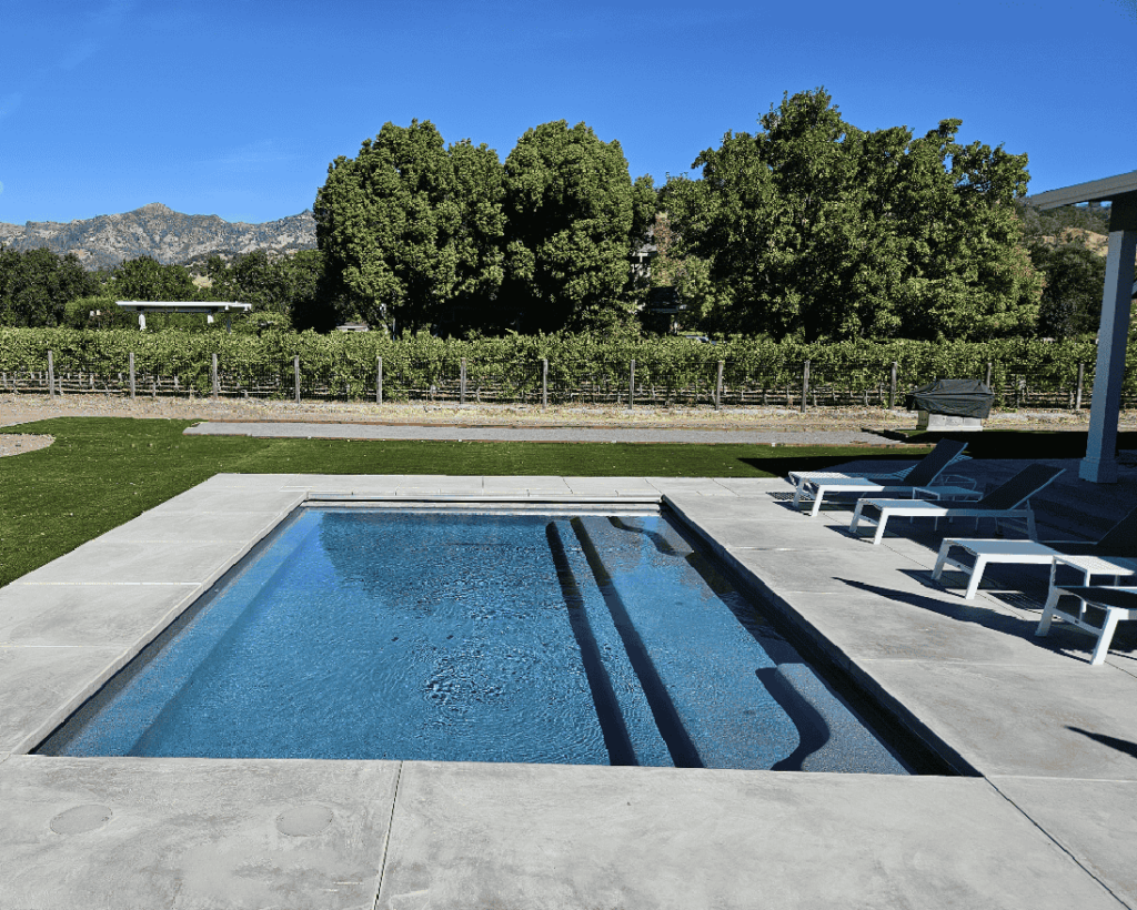 Pool with an automatic pool cover in the wine country with vineyard in the background.