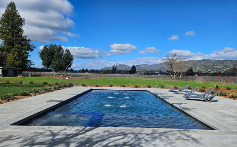 Large rectngular pool approx 800 square feet with an automatic pool cover and spa and deck jets in Napa, California